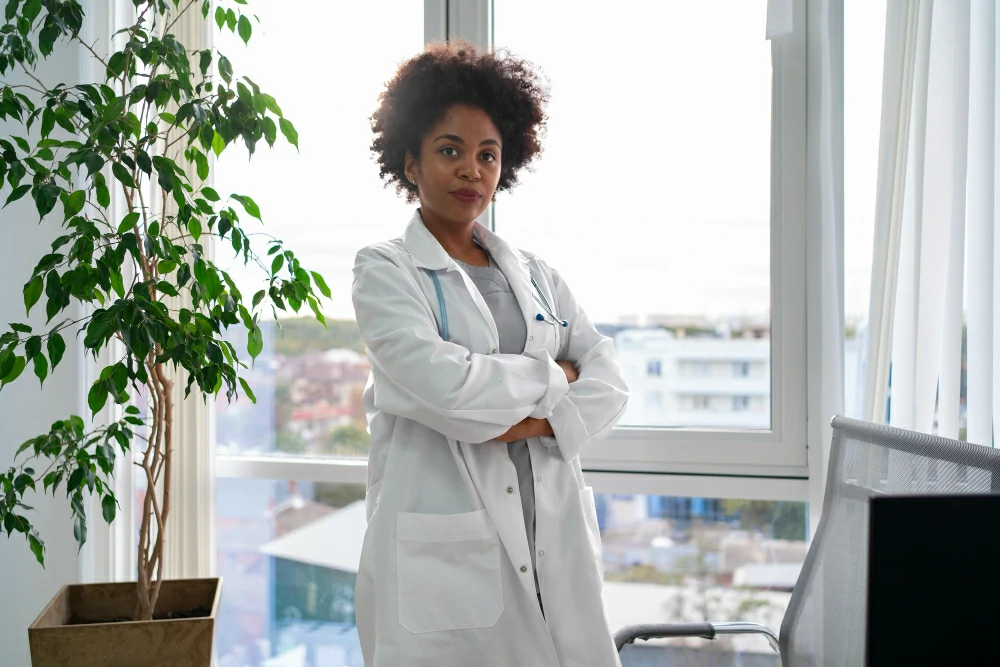 woman with a lab coat on standing with arms folded