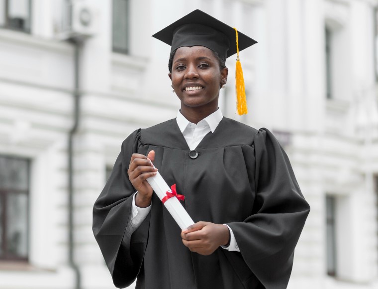 Woman in graduates gown and diploma